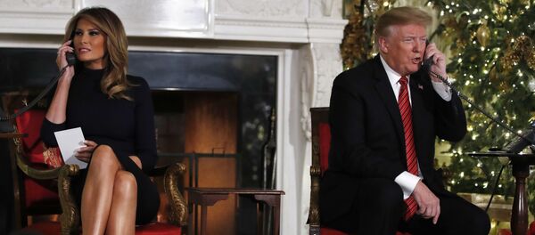 الرئيس الأمريكي دونالد ترامب وزوجته ميلانيا خلال تلقي معلومات عن مرور سانتا كلوز عشية عيد الميلاد - سبوتنيك عربي