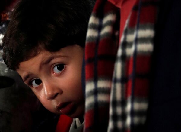 فتى مصري كاثوليكي ينظر خلال ليلة عيد الميلاد في كاتدرائية العذراء مريم بمدينة نصر - سبوتنيك عربي