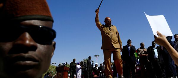 الرئيس السوداني عمر البشير ملوحا إلى أنصاره خلال مسيرة في الساحة الخضراء في الخرطوم - سبوتنيك عربي