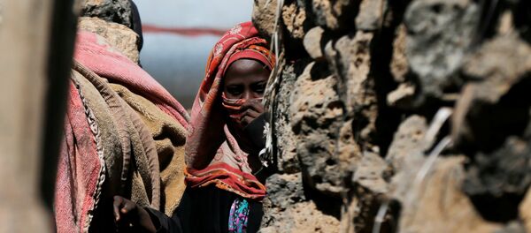 امرأة تقف بالقرب من كوخها في مخيم مؤقت للنازحين قرب صنعاء - سبوتنيك عربي