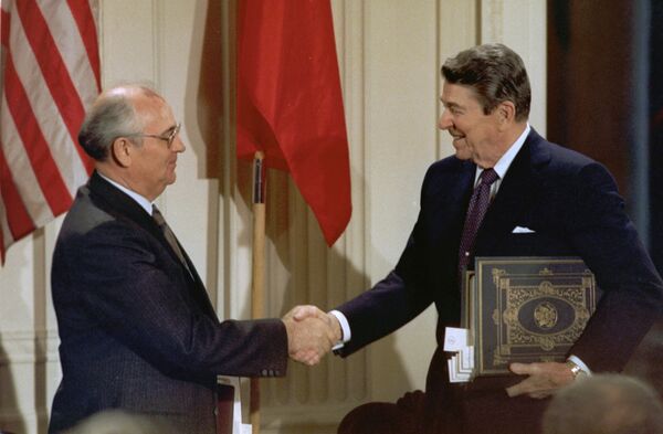 الرئيس الأمريكي رونالد ريغان والزعيم السوفياتي ميخائيل غورباتشوف يتصافحان بعد توقيع معاهدة الحد من الصواريخ المتوسطة والقصيرة المدى، واشنطن (7-10) عام 1987 - سبوتنيك عربي