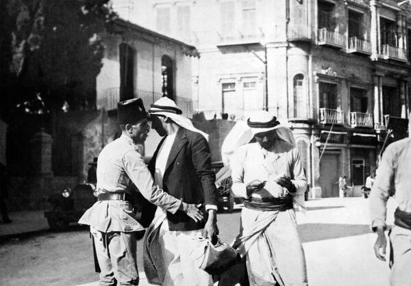 شرطي يقوم بالبحث عن فلسطينيين في أغسطس/ آب 1929 خلال الانتداب البريطاني في فلسطين، حيث وقعت مصادمات عنيفة بين الفلسطينيين العرب الذين عارضوا إقامة في وطن قومي للشعب اليهودي - سبوتنيك عربي