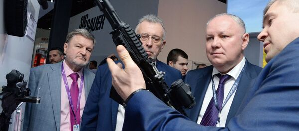 المدير العام لشركة روس أوبورونن إكسبورت، الكسندر ميخييف (يسار) يتفقد بندقية كلاشنيكوف -200  ، والتي صنعتها شركة كلاشنيكوف، في معرض آيدكس 2019 - سبوتنيك عربي