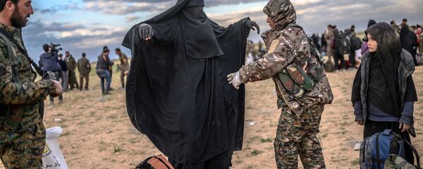 عضو في القوات الديموقراطية السورية قسد يتفحص امرأة بعد أن غادرت آخر موقع كان تحت سيطرة تنظيم داعش الإرهابي (المحظور في روسيا) في باغوز، في محافظة دير الزور شمال سوريا، 27 فبراير/ شباط 2019. عضو في القوات الديموقراطية السورية قسد يتفحص امرأة بعد أن غادرت آخر موقع كان تحت سيطرة تنظيم داعش الإرهابي (المحظور في روسيا) في باغوز، في محافظة دير الزور شمال سوريا، 27 فبراير/ شباط 2019. - سبوتنيك عربي