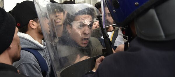 طلاب جزائريون يشتبكون مع قوات حفظ الأمن خلال مظاهرة في العاصمة الجزائر، وذلك خلال احتجاجات على محاولة الرئيس الجزائري المريض عبد العزيز بوتفليقة لولاية خامسة في 26 فبراير/ شباط 2019. - سبوتنيك عربي