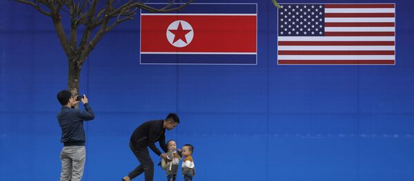 مواطنون يلتقطون صورة على خلفية علمي كوريا الشمالية والولايات المتحدة الأمريكية، في ظل القمة الأمريكية الكورية في هانوي، فيتنام 27 فبراير/ شباط 2019 - سبوتنيك عربي