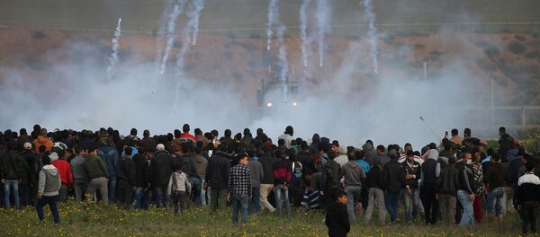 القوات الإسرائيلية تطلق قنابل الغاز المسيل للدموع باتجاه المتظاهرين الفلسطينيين خلال مظاهرة على السياج الحدودي بين إسرائيل وقطاع غزة، في جنوب قطاع غزة 22 فبراير/ شباط 2019 - سبوتنيك عربي