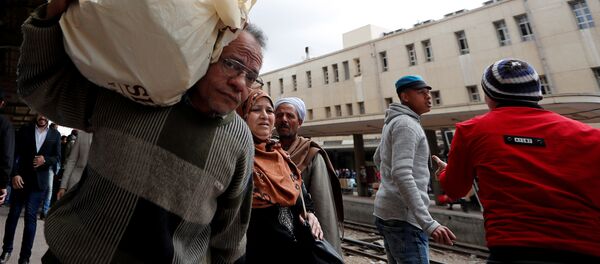 الناس يسيرون في محطة القطار الرئيسية بعد حريق تسبب في الوفيات والإصابات في القاهرة - سبوتنيك عربي