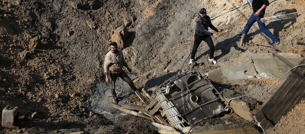 فلسطينيون يتفقدون موقع غارة جوية إسرائيلية على ميناء قيد الإنشاء في جنوب قطاع غزة - سبوتنيك عربي