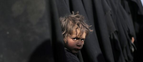 صبي ينظر إلى الكاميرا بالقرب من الباغوز محافظة دير الزور في سوريا صبي ينظر إلى الكاميرا بالقرب من الباغوز محافظة دير الزور في سوريا - سبوتنيك عربي