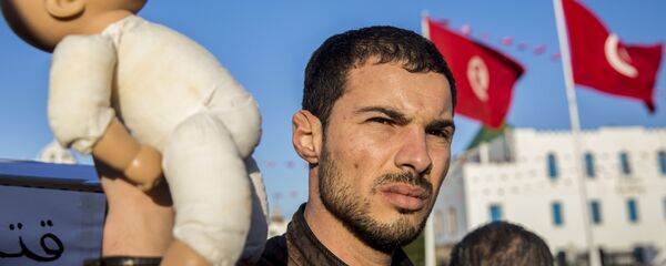 متظاهر في تونس يحمل دمية لطفل للتنديد بوفاة أطفال رضع في مستشفى حكومي - سبوتنيك عربي