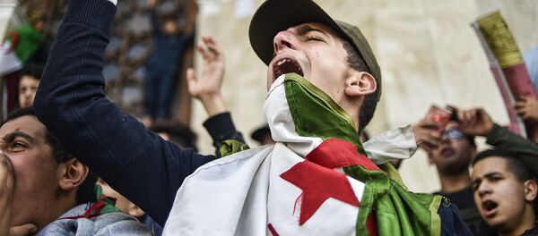 طلاب جزائريون يتظاهرون بالقرب من مكتب البريد المركزي وسط العاصمة الجزائر، ضد ترشيح الرئيس الجزائري عبد العزيز بوتفليقة لولاية رئاسية خامسة، 10 مارس/ آذار 2019 - سبوتنيك عربي