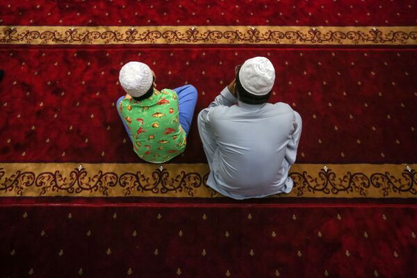 مسلمون أثناء الصلاة على أرواح ضحايا الهجوم الإرهابي على مسجدين في كرايستشيرش في نيوزيلندا، في مدينة هونغ كونغ 18 مارس/ آذار 2019 - سبوتنيك عربي