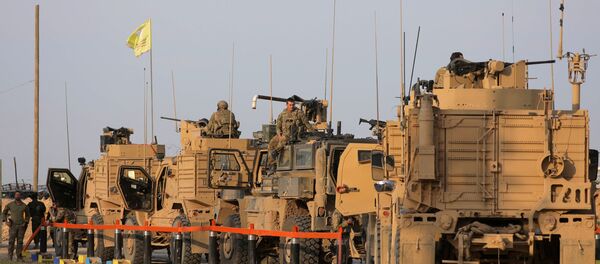 جنود أمريكيون يقفون بالقرب من شاحنات عسكرية في حقل العمر في دير الزور - سبوتنيك عربي