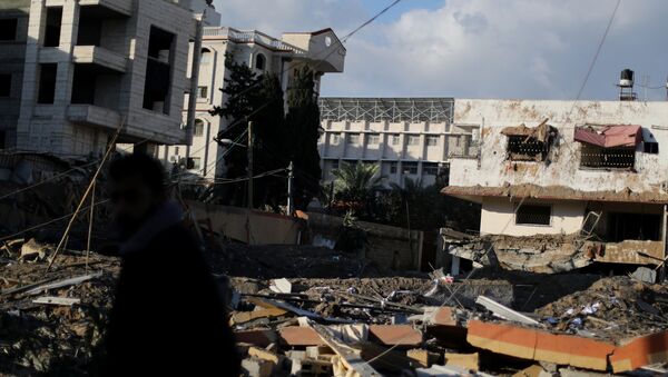 غزة، قطاع غزة، فلسطين - مواطنون غزيون بعد ليلة من قصف الطيران الحربي الإسرائيلي، مكتب إسماعيل هنية بعد القصف، 26 مارس/ آذار 2019 - سبوتنيك عربي