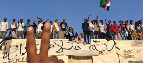 متظاهرون سودانيون يهتفون بشعارات خلال مظاهرة تطالب الرئيس السوداني عمر البشير بالتنحي خارج وزارة الدفاع في الخرطوم - سبوتنيك عربي