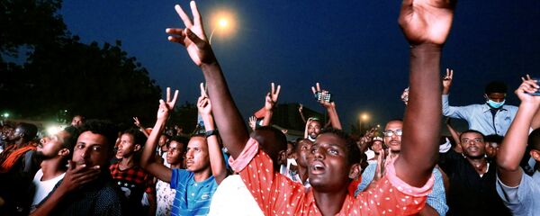 المتظاهرون السودانيون يرددون شعارات أثناء حضورهم مظاهرة احتجاج تطالب الرئيس السوداني عمر البشير بالتنحي خارج وزارة الدفاع في الخرطوم - سبوتنيك عربي