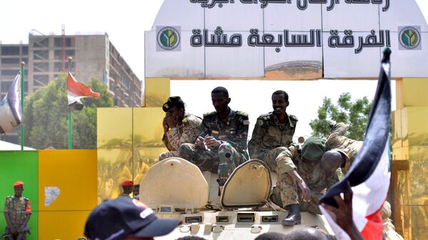 أفراد من الجيش السوداني يجلسون على حاملة جنود مدرعة بالقرب من وزارة الدفاع في الخرطوم - سبوتنيك عربي
