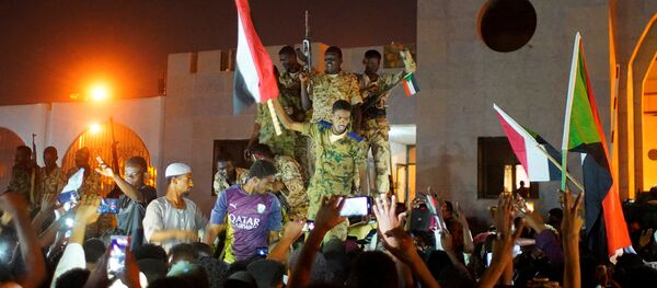 الجيش السوداني ينضم إلى المتظاهرين للاحتفال بعد تنحي وزير الدفاع عوض بن عوف كرئيس للمجلس العسكري الانتقالي الحاكم في البلاد - سبوتنيك عربي