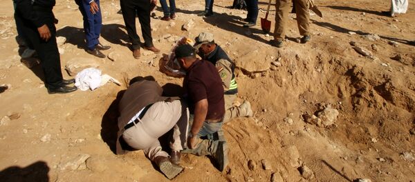 عراقيون من الدفاع المدني وأكراد يفحصون مقبرة جماعية اكتشفت للأكراد في غرب مدينة السماوة - سبوتنيك عربي