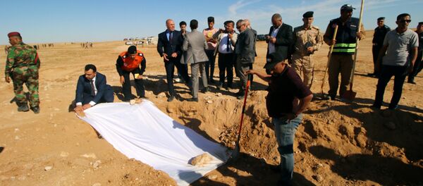 أعضاء من الدفاع المدني العراقي يغطون عظام مقبرة جماعية مكتشفة للأكراد غرب مدينة السماوة - سبوتنيك عربي