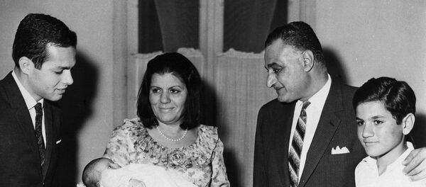 جمال عبد الناصر يلقي نظرة أولى على حفيده الثاني جمال مروان المولود لابنته منى في القاهرة وتحمله زوجة الرئيس تحية بينما والد الطفل أشرف مروان ينظر إلى اليسار وإلى اليمين أصغر أبناء ناصر عبد الحكيم - سبوتنيك عربي