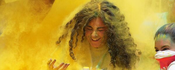 متطوعون يصبون مسحوقا من اللون الأصفر على المتسابقين الذين اجتازوا خط نهاية السباق، في أول مسابقة الألوان في الجيزة، مصر في 13 أبريل/ نيسان 2019 - سبوتنيك عربي