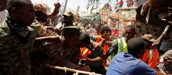 متظاهرون سودانيون يضربون رجلا يعتقد أنه عميل حكومي بينما يحاول الجنود إخراجه من الحشد في الخرطوم - سبوتنيك عربي