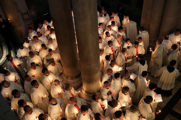 المصلون يشاركون في مسيرة خلال حفل غسل القدم الكاثوليكي في أسبوع عيد الفصح المقدس في كنيسة القيامة في مدينة القدس القديمة - سبوتنيك عربي