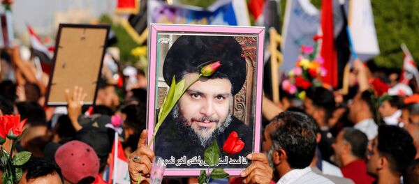 أنصار رجل الدين العراقي مقتدى الصدر يحملون صورة له خلال تجمع ضد تصريحات وزير الخارجية البحريني بالقرب من قنصلية البحرين في بغداد - سبوتنيك عربي