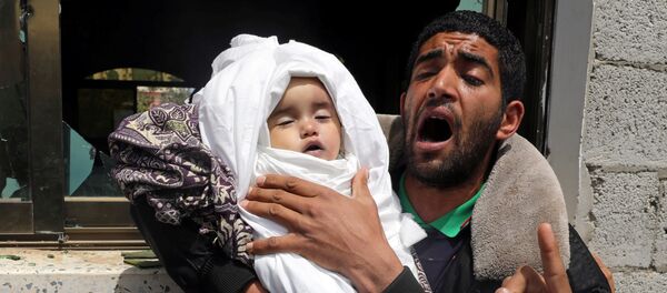 أحد أقارب الطفلة الفلسطينية صبا أبو عرار البالغة من العمر 14 شهرًا يحمل جثمانها خلال جنازتها في مدينة غزة - سبوتنيك عربي