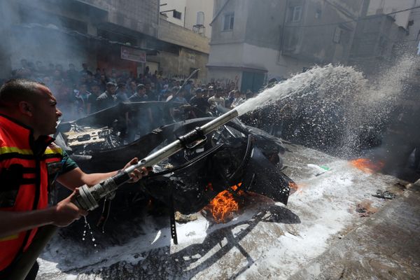 عضو في الدفاع المدني الفلسطيني يطفئ حريقا في سيارة القيادي الحمساوي حامد أحمد عبد الخضري الذي قتل في غارة جوية إسرائيلية في مدينة غزة - سبوتنيك عربي
