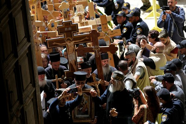 المصلون المسيحيون الأرثوذكس يحملون صليبًا خشبيًا إلى كنيسة القبر المقدس خلال موكب الجمعة الحزينة على طول طريق الدولوروسا في المدينة القديمة بالقدس - سبوتنيك عربي