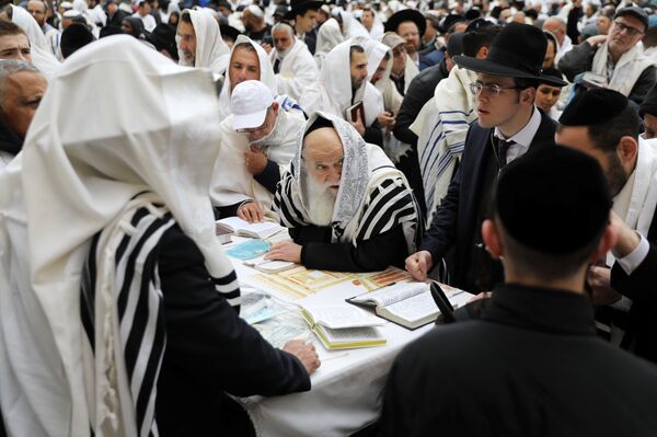 مصلون يهود خلال عطلة عيد الفصح اليهودي عند الحائط الغربي أقدس مكان للصلاة في اليهودية في البلدة القديمة بالقدس - سبوتنيك عربي