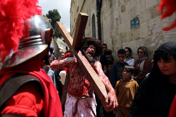 عابد مسيحي يعيد تمثيل رحلة المسيح على طول طريق دولوروسا خلال موكب الجمعة العظيمة في المدينة القديمة بالقدس - سبوتنيك عربي