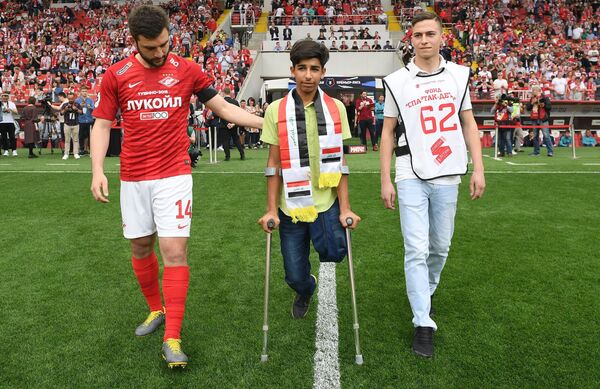 الفتى العراقي بطل صورة الرغبة في الحياة يركل كرة البداية في مباراة بالدوري الروسي - سبوتنيك عربي