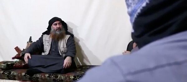 رجل ملتح مع زعيم داعش أبو بكر البغدادي في صورة التي التقطت من شريط فيديو نُشر في 29 أبريل 2019 - سبوتنيك عربي