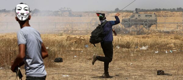 شباب فلسطينيون يقذفون الحجارة في شرق خان يونس، جنوب قطاع غزة، أثناء إحياء الذكرى الـ 71 للنكبة، 15 مايو/ أيار 2019 - سبوتنيك عربي