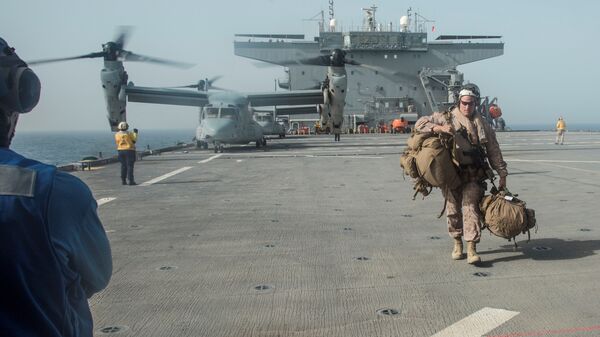 فرد من مشاة البحرية الأمريكية يحمل معداته على سطح حاملة الطائرات يو إس إس لويس ب. بولر في الخليج العربي - سبوتنيك عربي