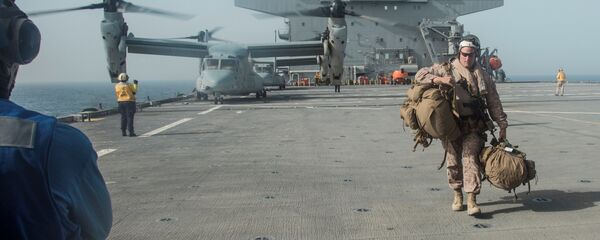 فرد من مشاة البحرية الأمريكية يحمل معداته على سطح حاملة الطائرات يو إس إس لويس ب. بولر في الخليج العربي - سبوتنيك عربي