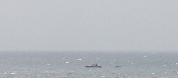  صورة أرشيفية: قارب تباع للحرس الثوري الإيراني بالقرب من حاملة الطائرات الأمريكية يو إس إس جورج بوش في مضيق هرمز، بينما تحلق طائرات الهليكوبتر التابعة للبحرية الأمريكية بالقرب من المكان، 21 مارس/ آذار 2017 - سبوتنيك عربي