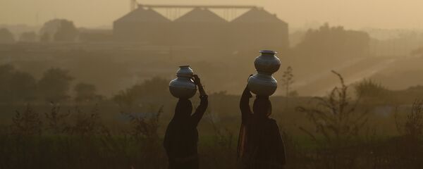 باكستانيات يحملن المياه إلى منازلهن في أمسية ضبابية على مشارف إسلام أباد - سبوتنيك عربي