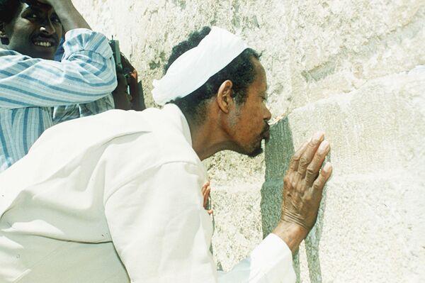 يهودي إثيوبي وصل إلى إسرائيل في عملية سولومون الجوية الضخمة وهو يقبل حجرًا من الحائط الغربي - سبوتنيك عربي