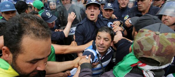 يواجه المتظاهرون وضباط الشرطة بعضهم البعض خلال احتجاج للمطالبة بتأجيل الانتخابات الرئاسية في الجزائر العاصمة - سبوتنيك عربي