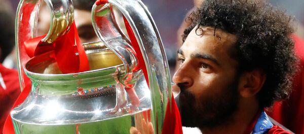 محمد صلاح يطبع قبلة على كأس دوري أبطال أوروبا بعد فوز فريقه ليفربول باللقب، 1 يونيو/حزيران 2019 - سبوتنيك عربي