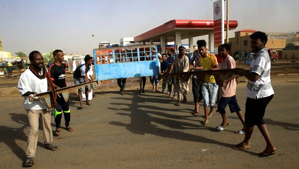 متظاهرون سودانيون يقيمون حاجزًا في أحد الشوارع لمطالبة المجلس العسكري الانتقالي في البلاد بتسليم السلطة إلى المدنيين - سبوتنيك عربي