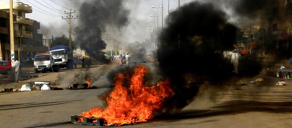 متظاهرون سودانيون يستخدمون الإطارات المحترقة لإقامة حاجز في أحد الشوارع متظاهرون سودانيون يستخدمون الإطارات المحترقة لإقامة حاجز في أحد الشوارع - سبوتنيك عربي