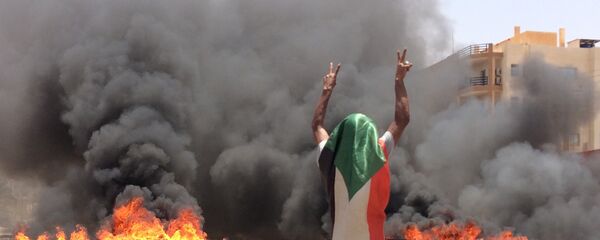 متظاهر سوداني يلوح بعلامة النصر بعد فض اعتصام المعارضة في السودان متظاهر سوداني يلوح بعلامة النصر بعد فض اعتصام المعارضة في السودان - سبوتنيك عربي