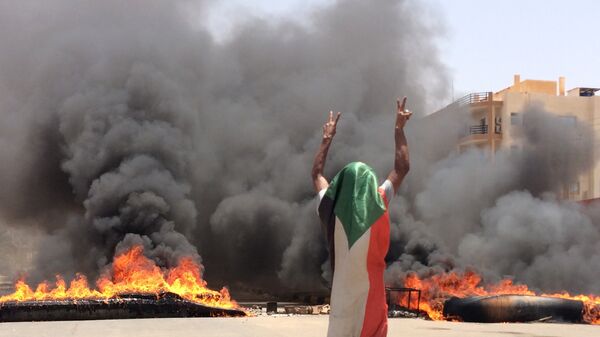متظاهر سوداني يلوح بعلامة النصر بعد فض اعتصام المعارضة في السودان - سبوتنيك عربي