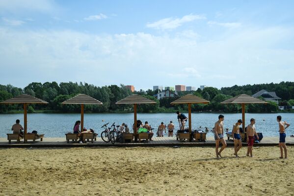 المصطافون على شاطئ منطقة ميشيرسكويه للترفيه والاستجمام في موسكو - سبوتنيك عربي